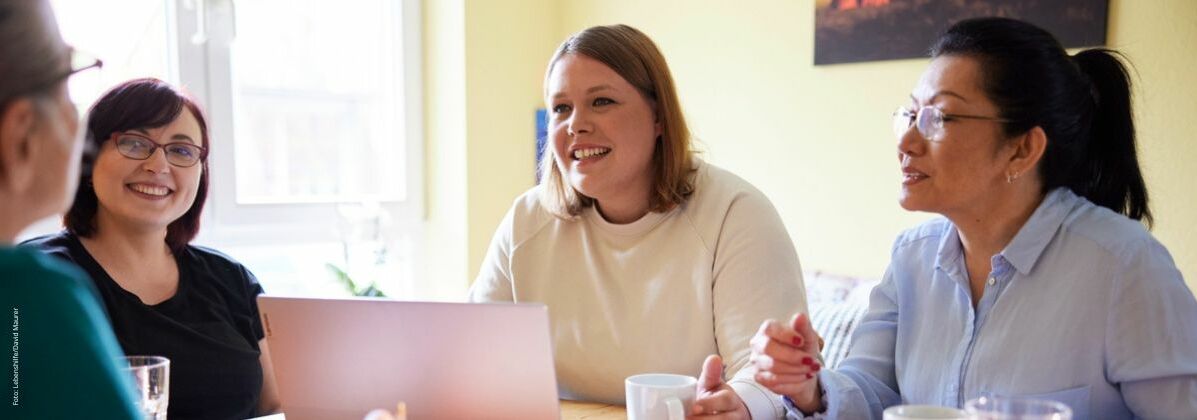 Mehrere lächelnde Frauen im Gespräch. Die Lebenshilfe Würzburg bietet vielfältige Fortbildungen für Kunden, Eltern, Mitarbeiter und Interessierte an.