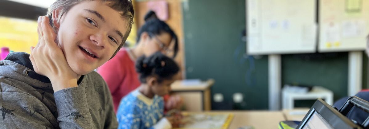 Ein lächelnder Junge in einem Klassenraum. Die Christophorus-Schule der Lebenshilfe Würzburg ist ein privates Förderzentrum mit dem Schwerpunkt geistige Entwicklung